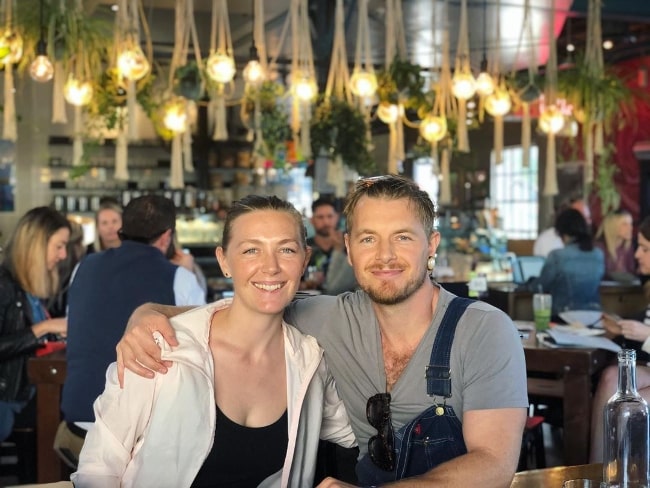 Rick Cosnett as seen while smiling for a picture alongside Michelle Alexandra at The Rose Venice in February 2020