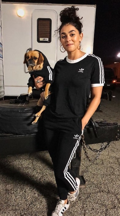 Natacha Karam smiling for a picture along with her dog in December 2019