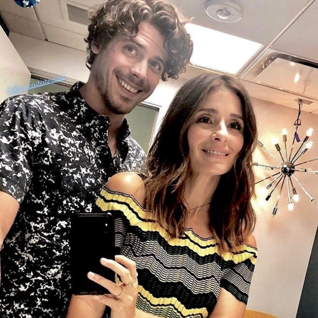 François Arnaud smiling in a mirror selfie alongside Shiri Appleby in July 2018