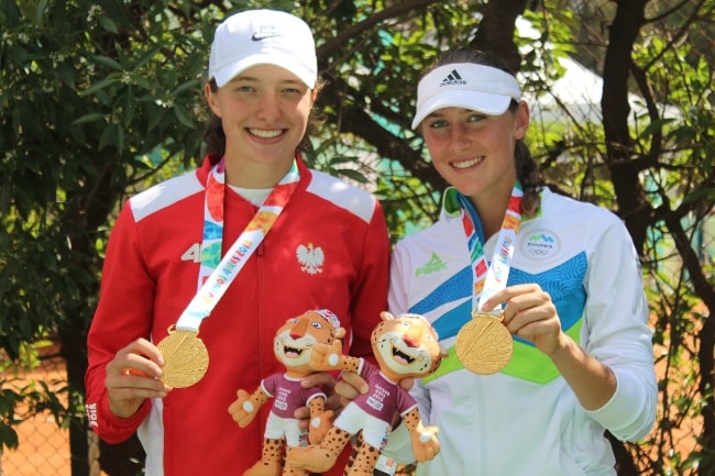 Iga Świątek (Left) and Kaja Juvan posing as the 2018 Summer Youth Olympics gold medallists in girls' doubles