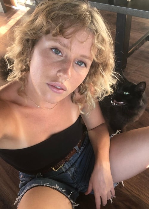 Lindsley Register clicking a selfie with Ivan the cat in the background in Los Angeles, California in August 2020