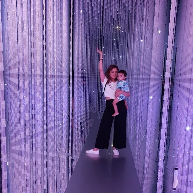 Nisha Agarwal posing for a picture while holding her son at ArtScience Museum in Singapore in June 2019