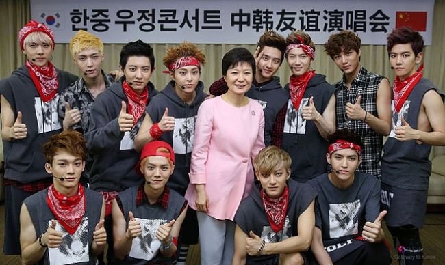 Members of EXO as seen posing with South Korean President Park Geun-hye in 2013