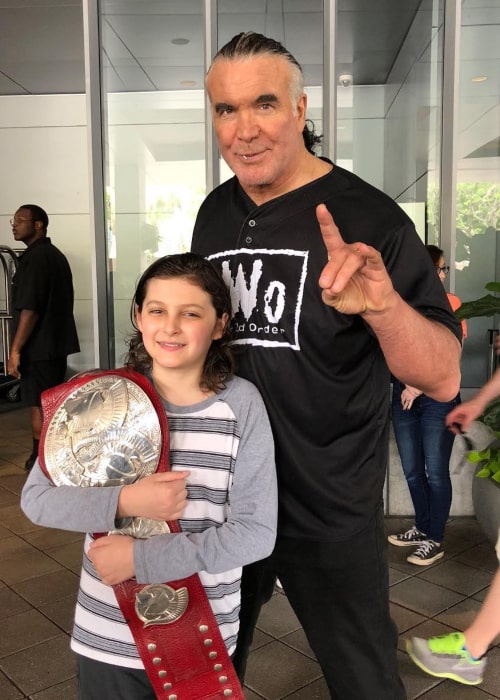 Scott Hall posing with a young fan in April 2018