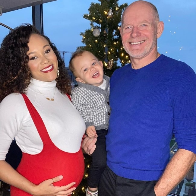 Ashley Darby smiling in a picture with her family and showing her baby bump in December 2020