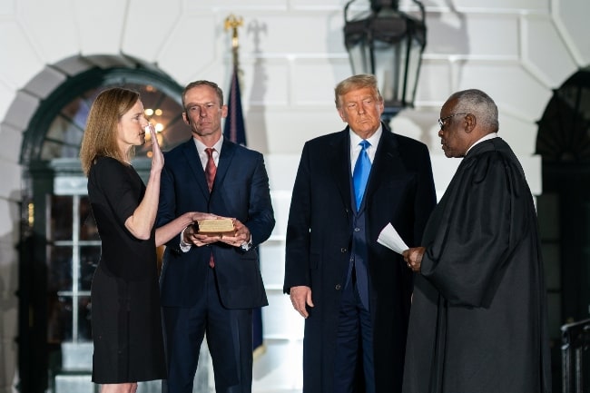 From Left - Amy Coney Barrett, Jesse M. Barrett, President Trump, and Supreme Court Associate Justice Clarence Thomas at the swearing-in ceremony of Judge Amy as Supreme Court Associate Justice in 2020