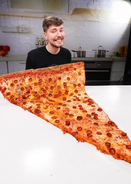 MrBeast in a picture that was taken in August 2020, with the largest slice of pizza of the world