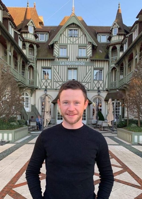 Devon Murray smiling for a picture at Hôtel Barrière Le Normandy Deauville in February 2019