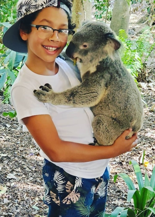 Adrian Groulx smiling for the camera while holding a koala