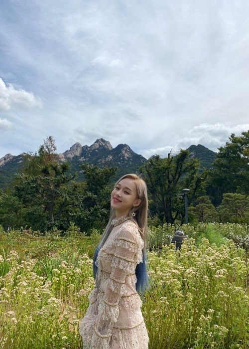 Winter as seen while smiling for a picture with a beautiful backdrop