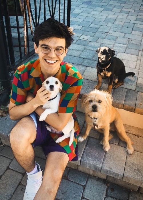 MacKenzie Bourg smiling for a picture with his furry friends in August 2019