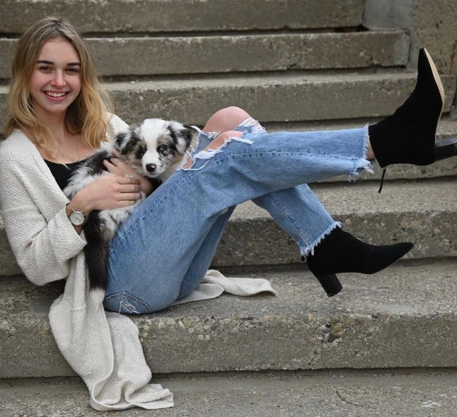 Nikki Roumel posing for a picture with her dog in December 2020