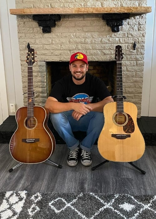 Chayce Beckham posing for a picture with 2 guitars in June 2021