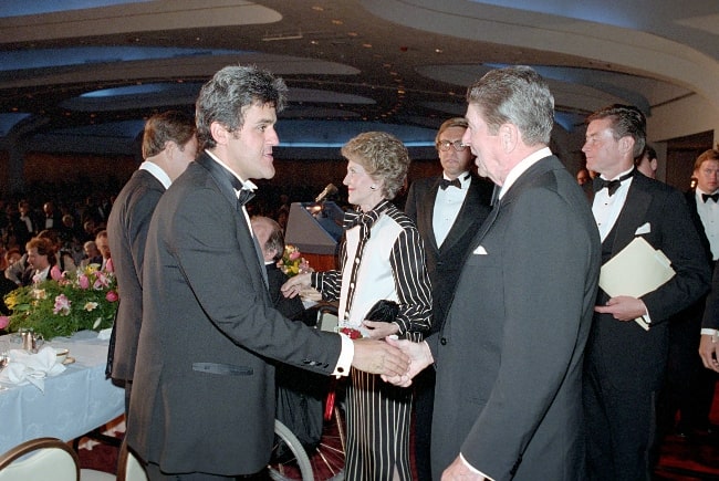 Jay Leno (Left) and President Ronald Reagan pictured while shaking hands at The White House Correspondents Association Dinner at The Hilton Hotel in Washington DC