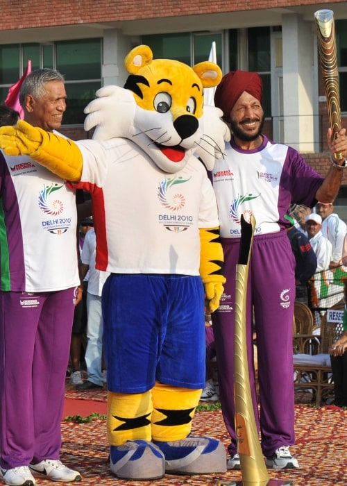 Milkha Singh holding the Queen's Baton 2010 Delhi with another athlete G S Virithi and Shera, the Mascot of Commonwealth Games 2010 Delhi, at the Cricket Stadium in Chandigarh on July 3, 2010