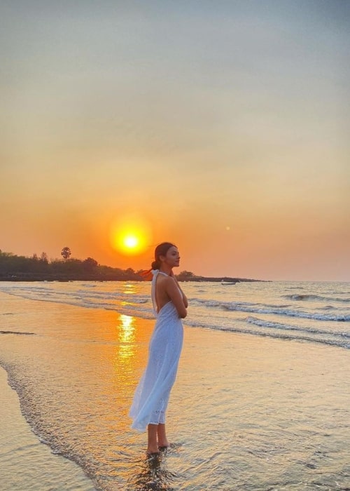 Pranali Rathod posing for a picture by a beach while enjoying a beautiful sunset in March 2021