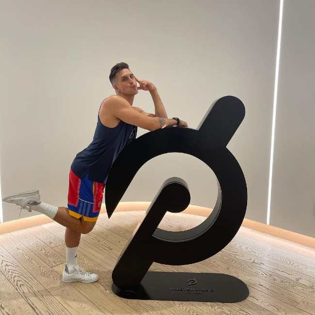 Cody posing with the Peloton brand logo in 2021