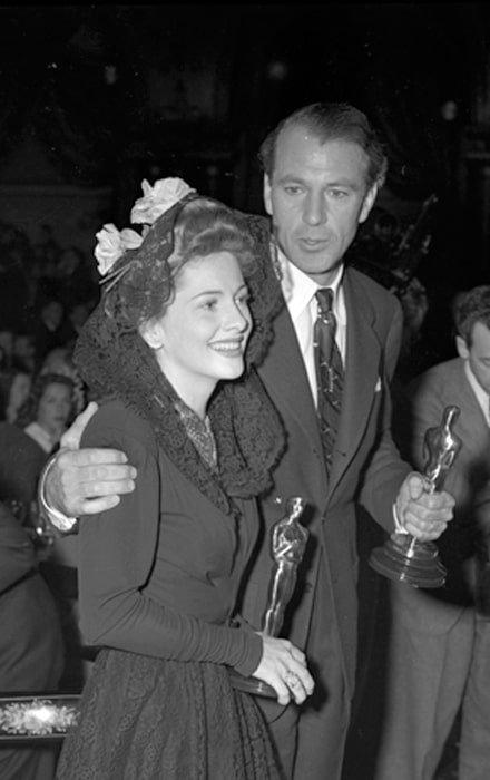 Gary Cooper and Joan Fontaine pictured while holding their Oscars at the Academy Awards after party, 1942