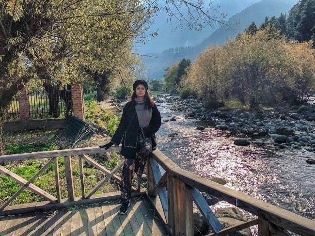 Madhura Naik posing for a picture with a stunning backdrop in Pahalgam in Jammu and Kashmir, India in June 2021