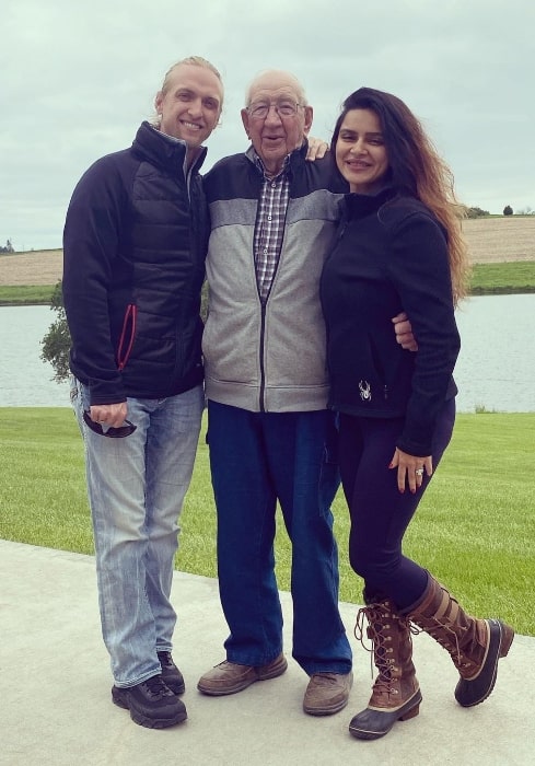 Aashka Goradia smiling for a picture with her husband and grandfather-in-law in Omaha, Nebraska