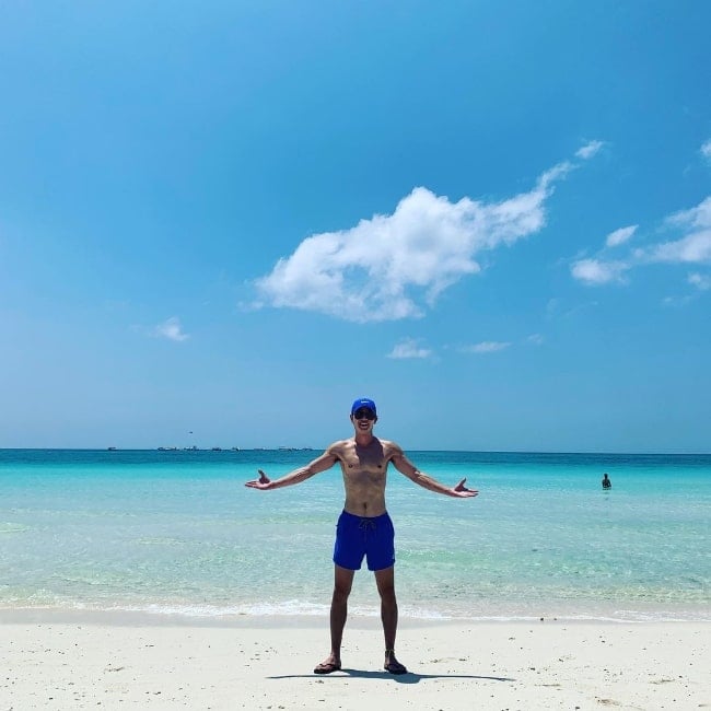 Lee Tae-sun posing shirtless for a picture while enjoying his time at a beach in 2019
