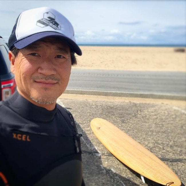 Tom Choi as seen while taking a selfie with his surfing board in the background at Bolsa Chica State Beach in California in March 2020