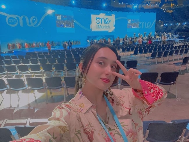 Nicole Ishida clicking a selfie at the One Young World Summit in Germany in 2021