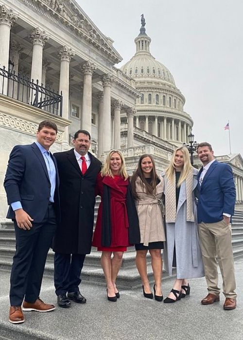 Marjorie Taylor Greene (seen in red) on the Capitol steps with her family