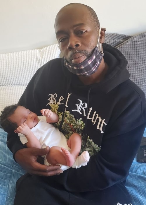 Rappin' 4-Tay posing for a picture with his grandchild