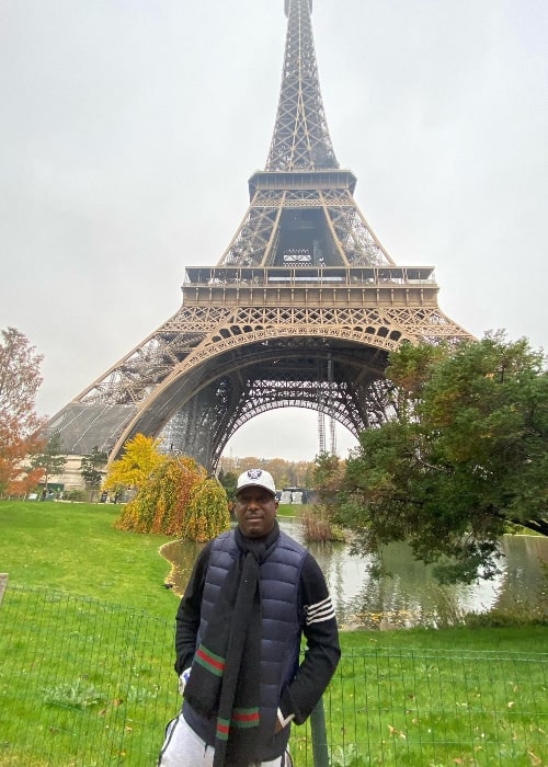 Ras Kass posing for a picture with Eiffel Tower in the background in Paris, France in November 2021