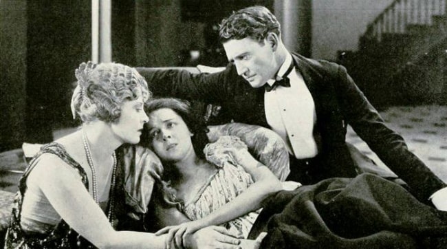From Left to Right - Gertrude Astor, Colleen Moore, and Richard Dix in a still from the American romantic drama film 'The Wall Flower' (1922)