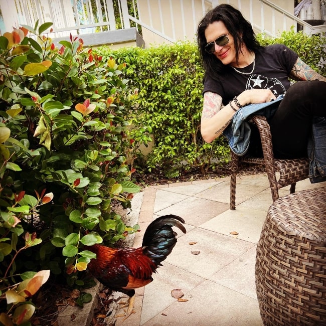 Todd Kerns smiling while looking at a rooster in Key West, Florida in January 2023