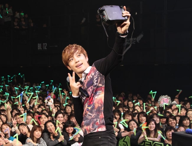 Seven pictured while taking a selfie at a fanmeeting in Japan in 2011
