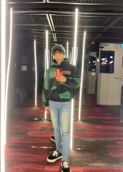Woohyun clicking a mirror selfie in December 2021