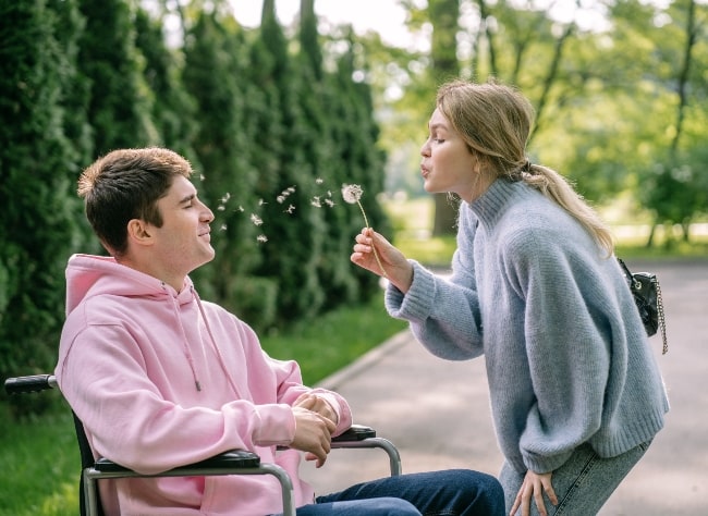 girl blowing dandelion flower