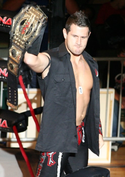 Alex Shelley as seen while posing with a TNA World Tag Team Championship belt at a TNA live event in 2010
