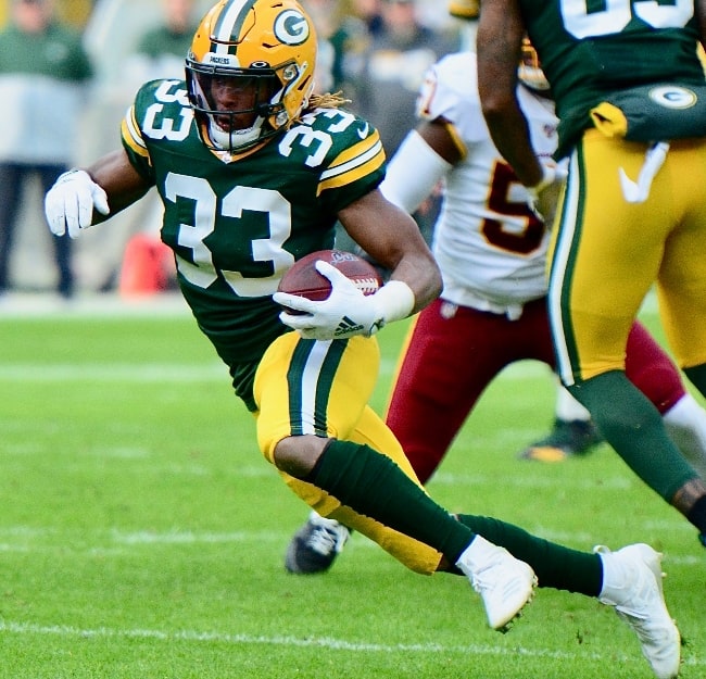 Aaron Jones as seen while carrying the ball for the Green Bay Packers during a game against the Washington Commanders on December 8, 2019