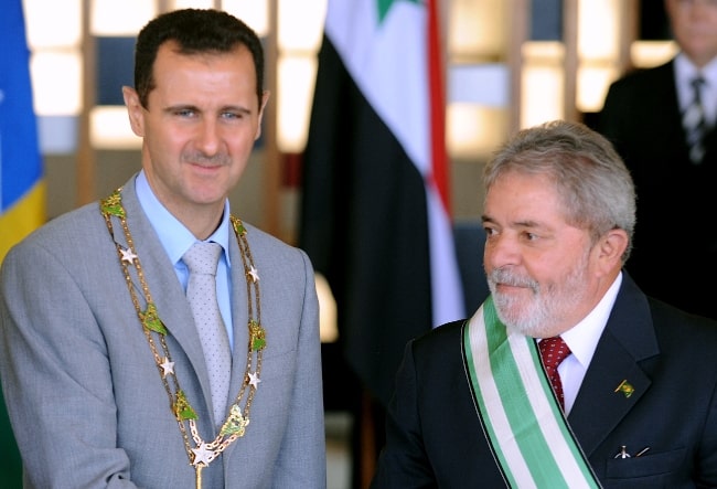 Bashar al-Assad (Left), pictured while wearing the 'Grand Collar' of the National Order of the Southern Cross, accompanied by Brazilian President Luiz Inácio Lula da Silva in Brasília on June 30, 2010