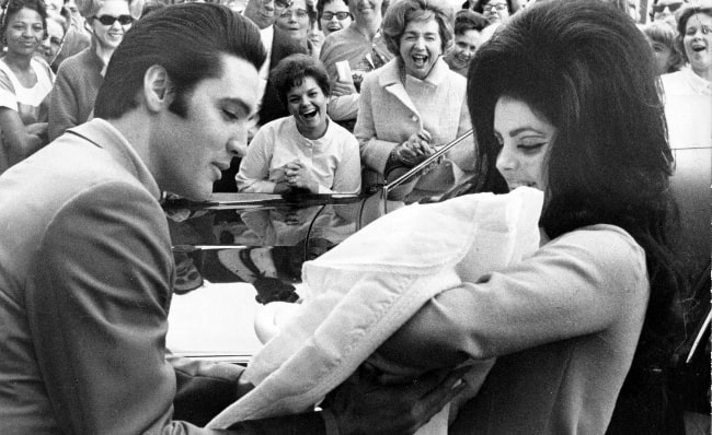 Priscilla Presley and Elvis Presley as seen with newborn Lisa Marie in a black-and-white picture in February 1968