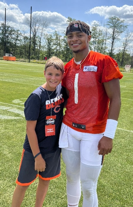 Justin Fields as seen while posing for a photo with a young fan at training camp on July 30, 2022