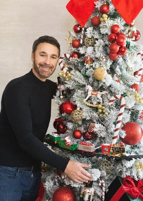 Raoul Bova as seen while smiling for a picture with a Christmas tree in December 2022